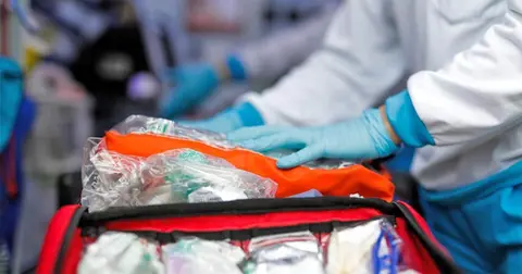 Una sanitaria prepara el material en la ambulancia