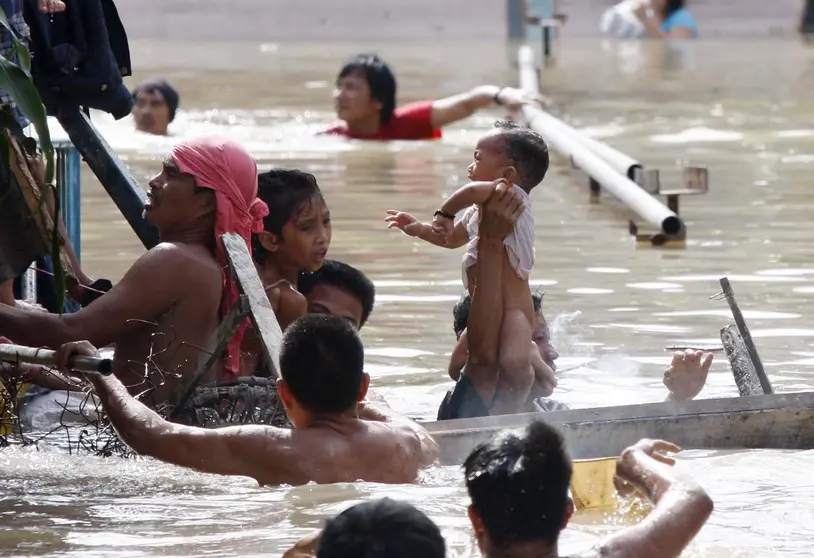 DEN04 SAN PEDRO (FILIPINAS) 29.09.09.: Habitantes tratan de rescatar a un beb&eacute; tras el derrumbe de una casa como consecuencia de las inundaciones provocadas por la tormenta tropical "Ketsana", en San Pedro, en la provincia de Laguna, Filipinas, hoy martes 29 de septiembre. El n&uacute;mero de v&iacute;ctimas ascendi&oacute; hasta las 240, con 37 desaparecidos, seg&uacute;n datos oficiales. Cerca de dos millones de personas se han visto afectados por el diluvio en Manila y en las provincias del norte, de acuerdo con el Consejo de Coordinaci&oacute;n Nacional de Desastres. EFE/Dennis M. Sabangan
