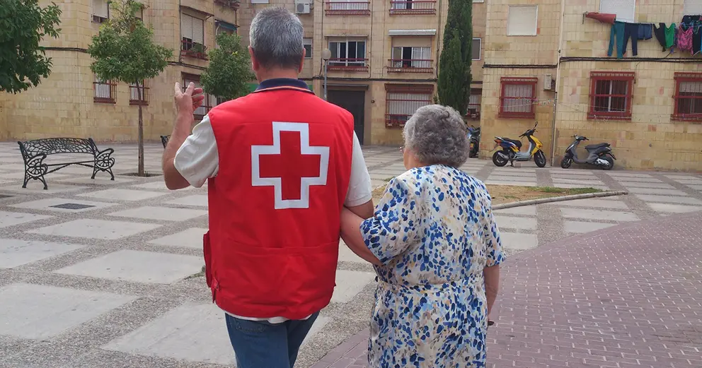 Voluntario de Cruz Roja junto a una mujer mayor