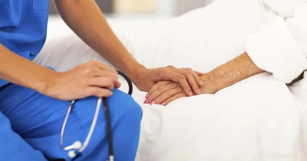 medical doctor comforting senior patient