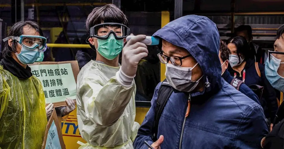 Un hombre toma la temperatura a otro en Hong Kong por el brote del nuevo coronavirus. | WILLIE SIAU/SOPA IMAGES VIA ZUMA / DPA