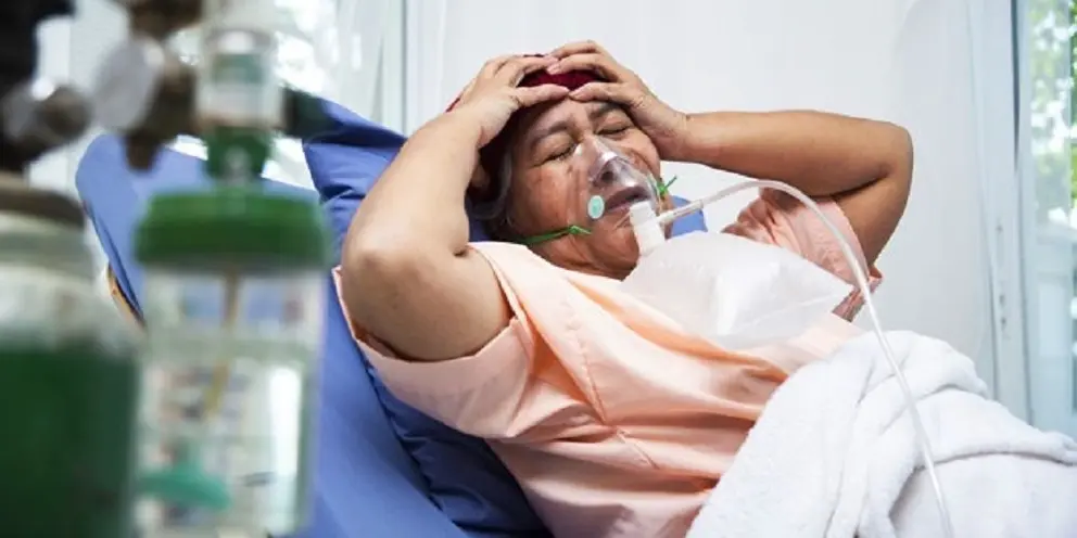 Elderly senior woman patients put hands on her head with headache in hospital - senior female medical and healthcare concept