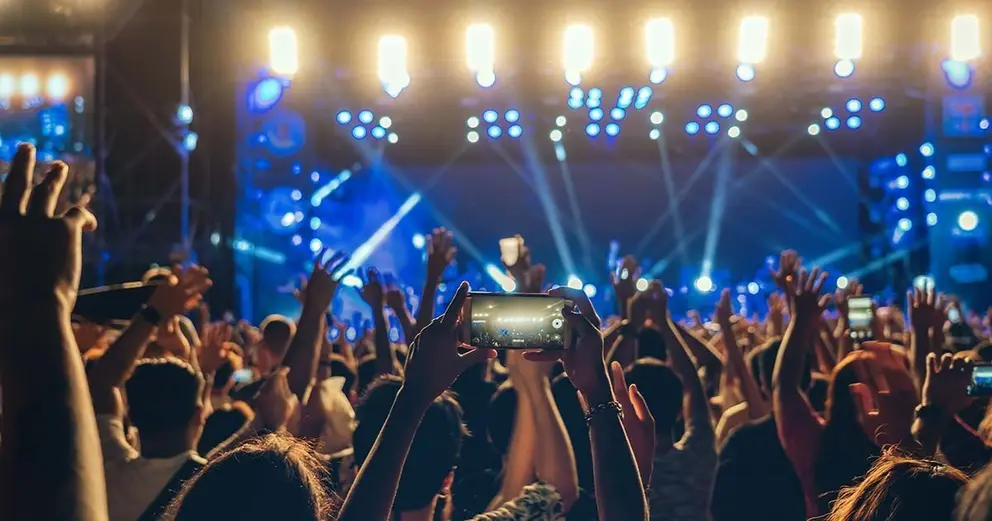Concert crowd of Music fanclub hand using cellphone taking video record or Live stream with superstar songer, happy new year, christmas and festival concept