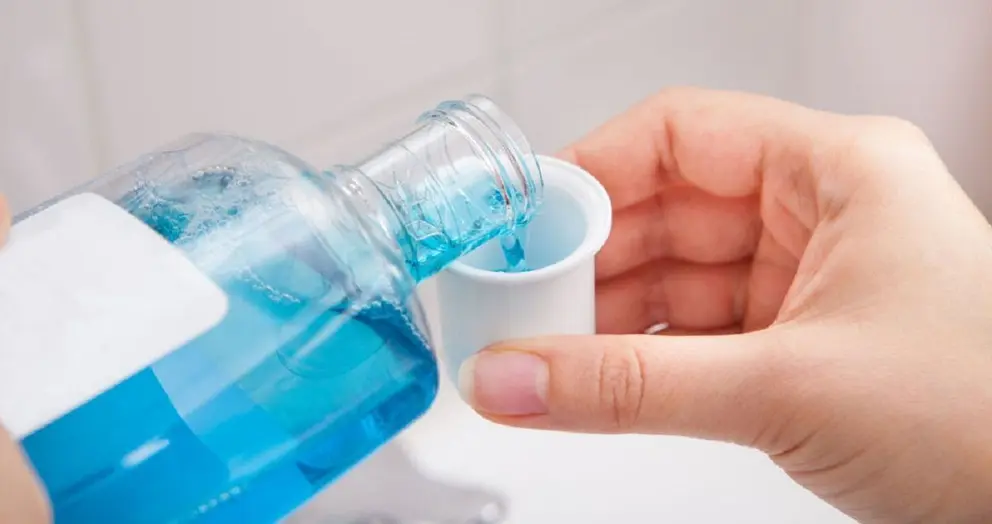 Close-up Of Person's Hand Pouring Liquid In Container