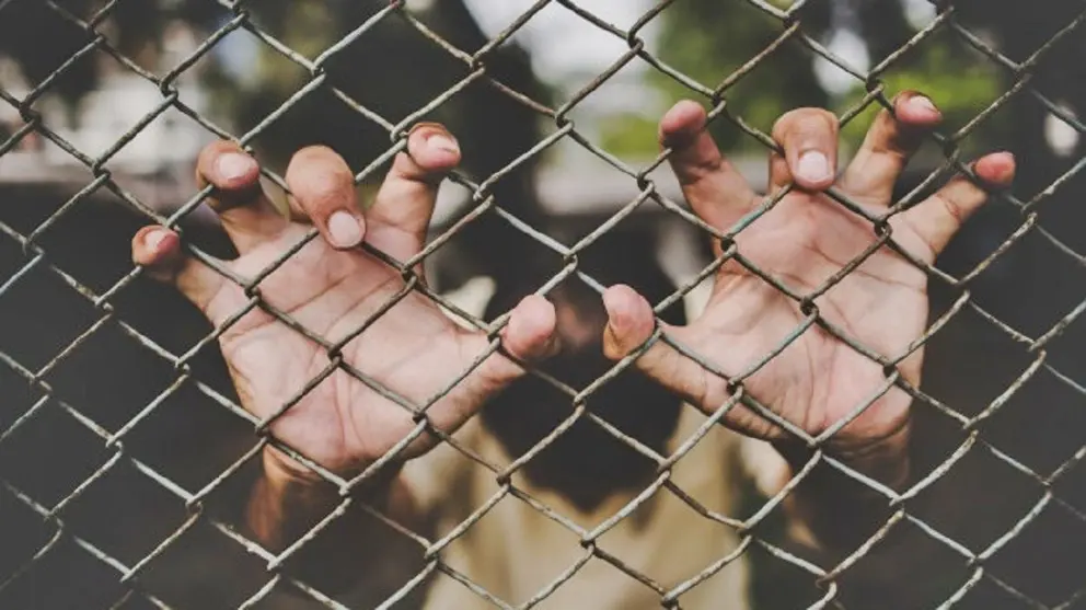 Persona en una valla | Imagen de Archivo