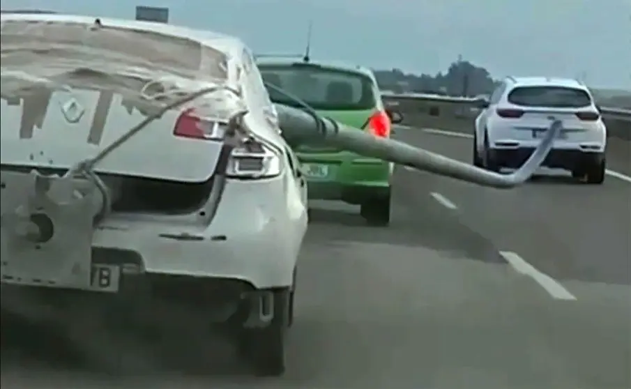 Renault de color blanco portando una farola que sobresale del veh&iacute;culo