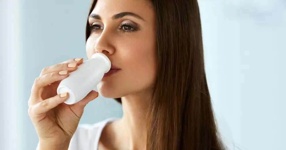 Mujer tomando probi&oacute;tico