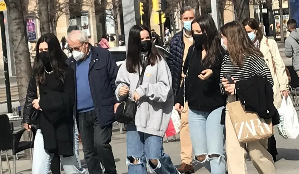 J&oacute;venes con mascarilla paseando