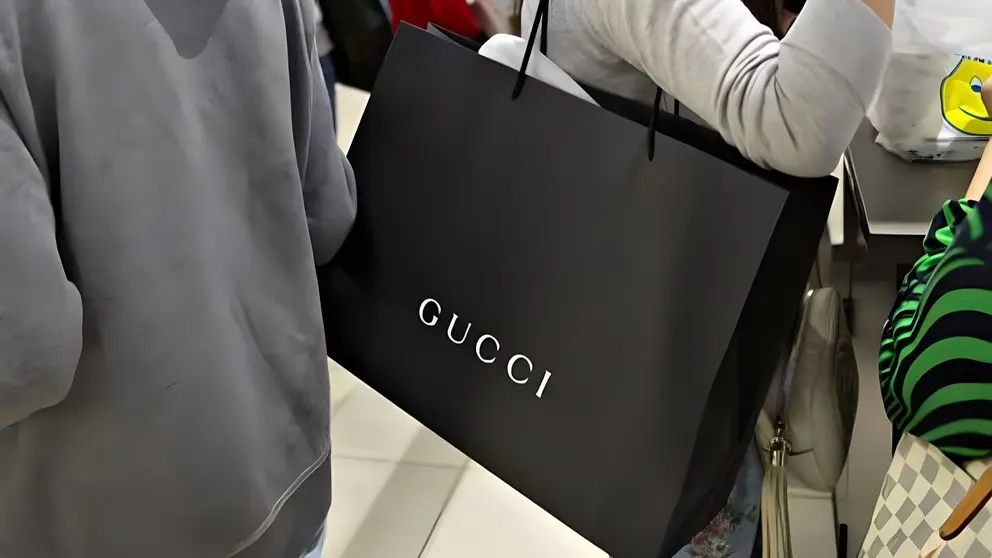Mujer amante de Gucci con bolsa de compra de la marca