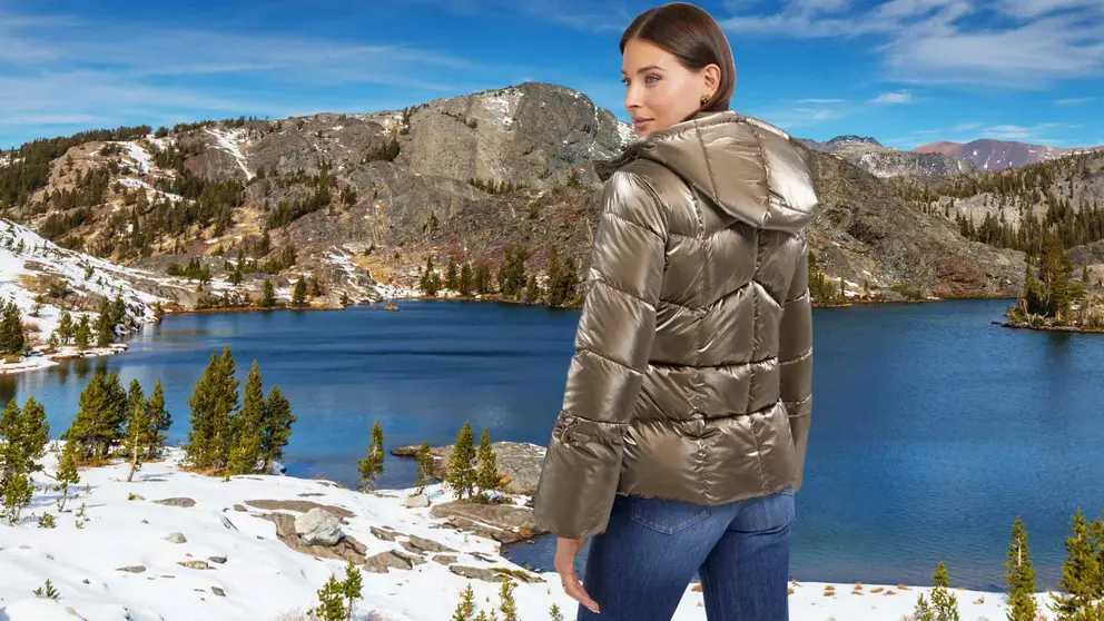 Mujer con Plum&iacute;fero efecto laminado espejo de GUESS con fondo de monta&ntilde;as de Sierra Nevada, Granada