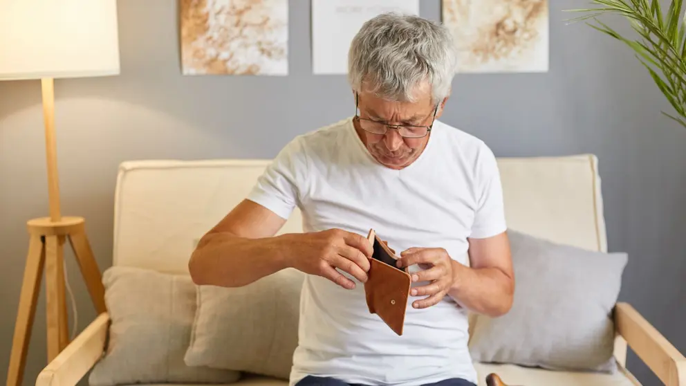 Hombre jubilado mira su cartera