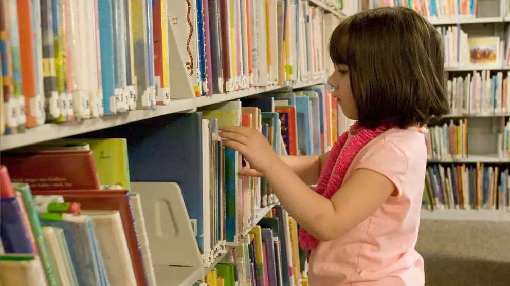 Una ni&ntilde;a en una biblioteca