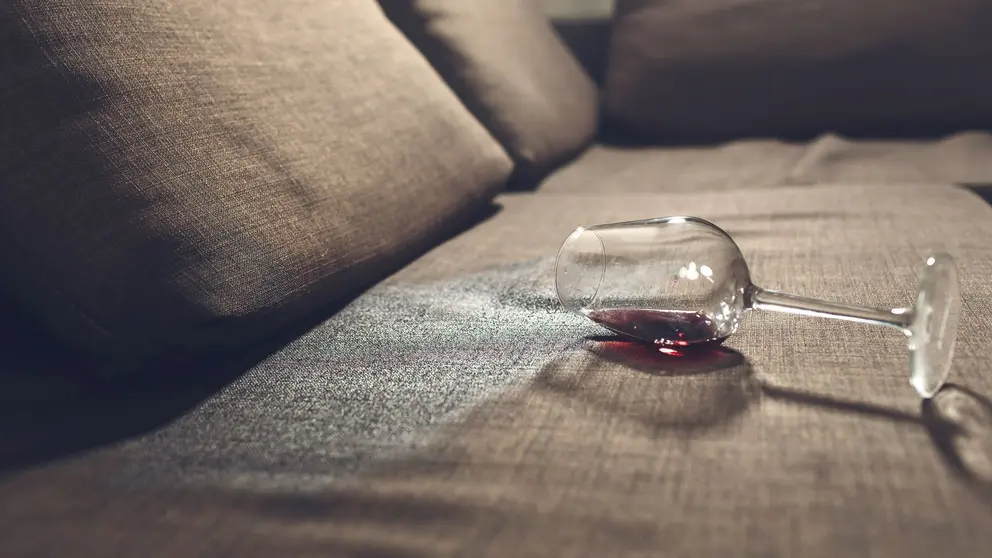 Copa de vino derramada en el sof&aacute;
