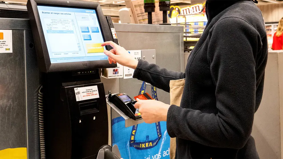 Mujer paga con tarjeta en la tienda de muebles y decoraci&oacute;n IKEA