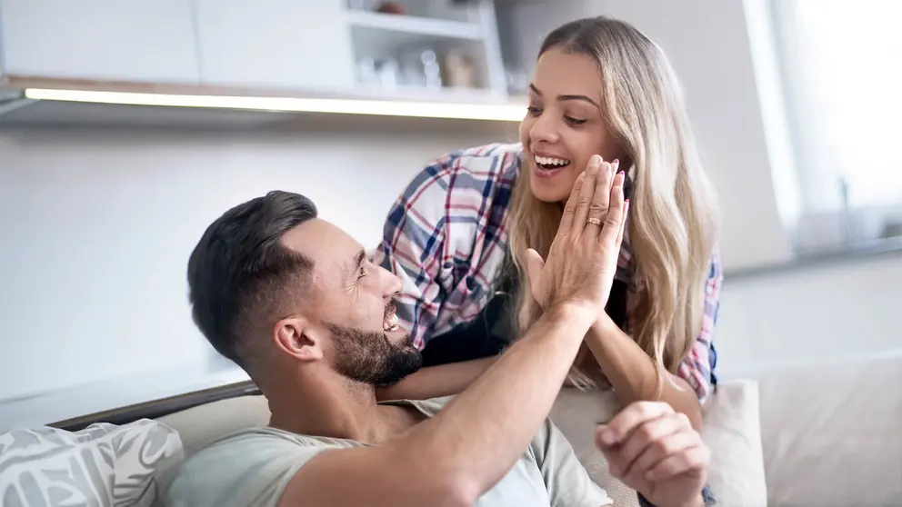 Pareja feliz tras recibir una buena noticia econ&oacute;mica