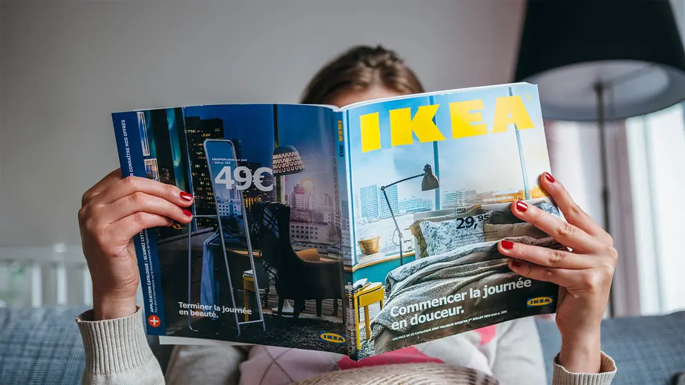 Mujer en su sof&aacute; con el cat&aacute;logo de IKEA
