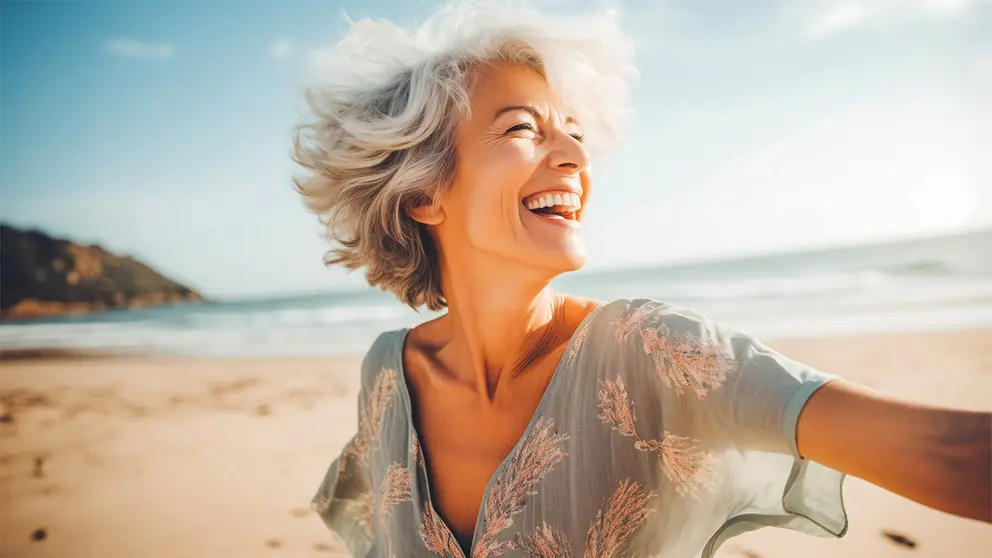 Mujer adulta disfrutando de la pensi&oacute;n por jubilaci&oacute;n en la playa