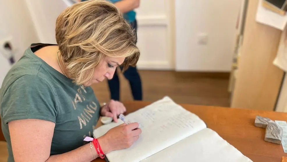 Susana D&iacute;az firmando un documento 