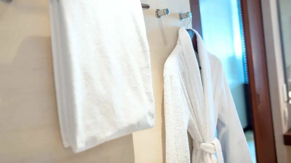 Toalla y albornoz colgados en el ba&ntilde;o