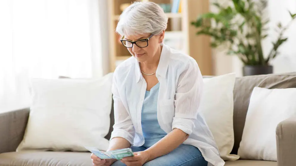 Una pensionista cuenta el dinero recibido tras la &uacute;ltima subida de la Seguridad Social