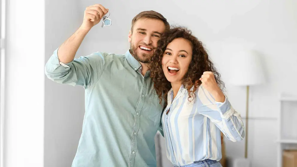 Dos j&oacute;venes con las llaves de su nueva vivienda