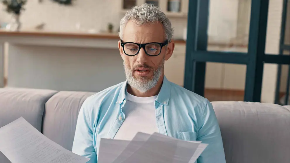 Un pensionista revisa documentos de la Seguridad Social