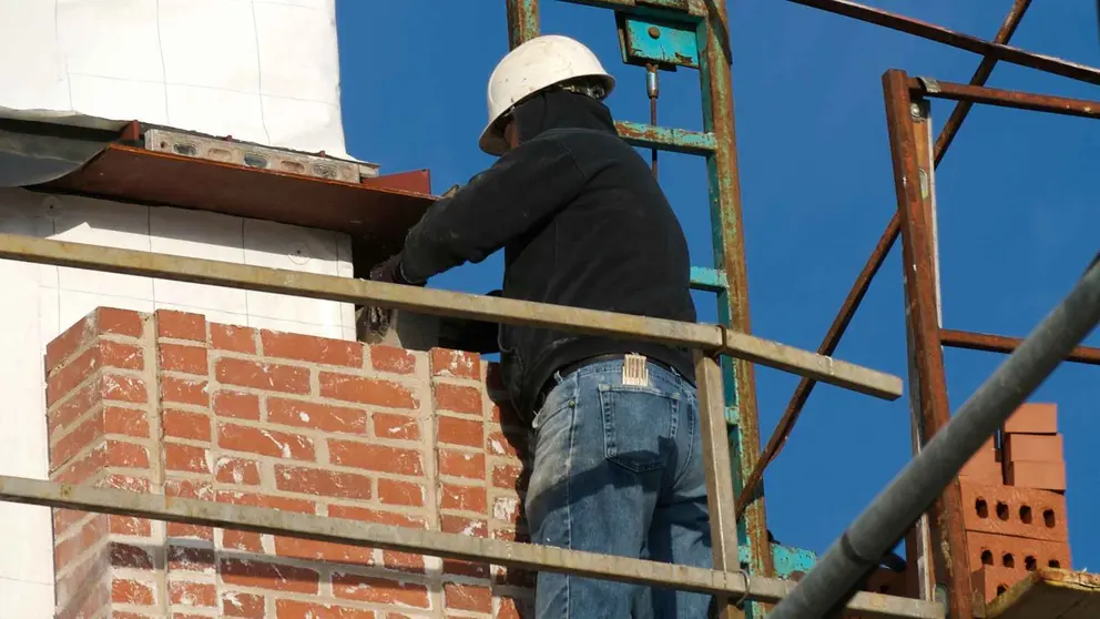 Un obrero subido a un andamio