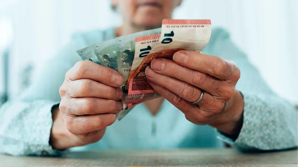 Una pensionista cuenta el dinero de su pensi&oacute;n en el mes de mayo
