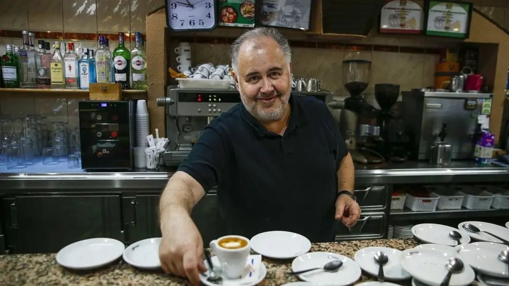 Un camarero sirve un caf&eacute; en un bar