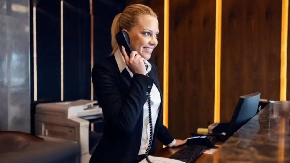 Una persona atiende al tel&eacute;fono en un hotel