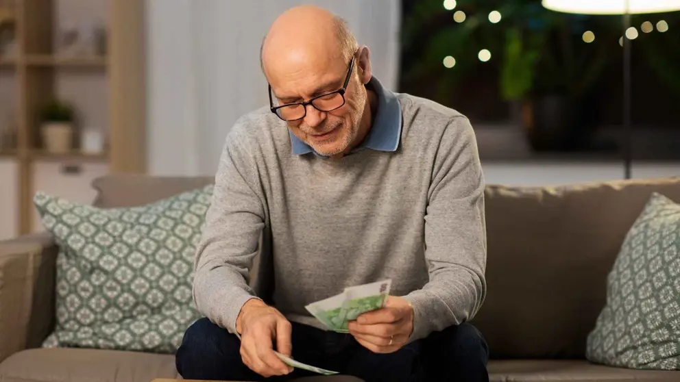 Un pensionista cuenta el dinero de su pensi&oacute;n de jubilaci&oacute;n
