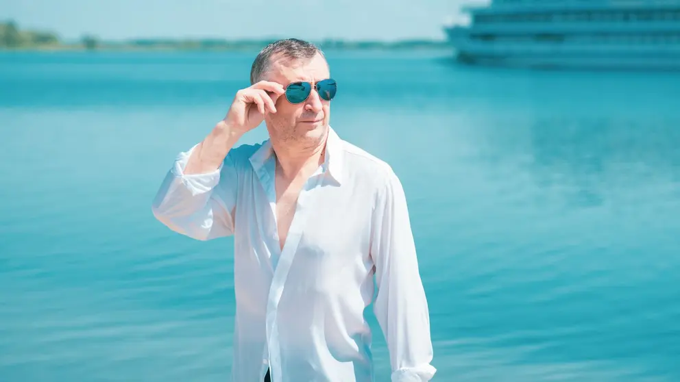 Hombre pensionista prejubilado disfruta de un d&iacute;a de playa en verano