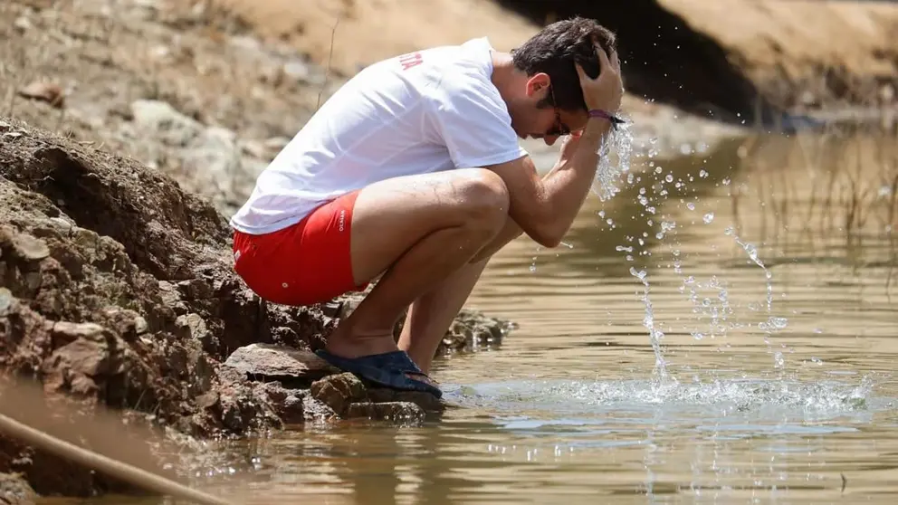 Un hombre se refresca en un pantano