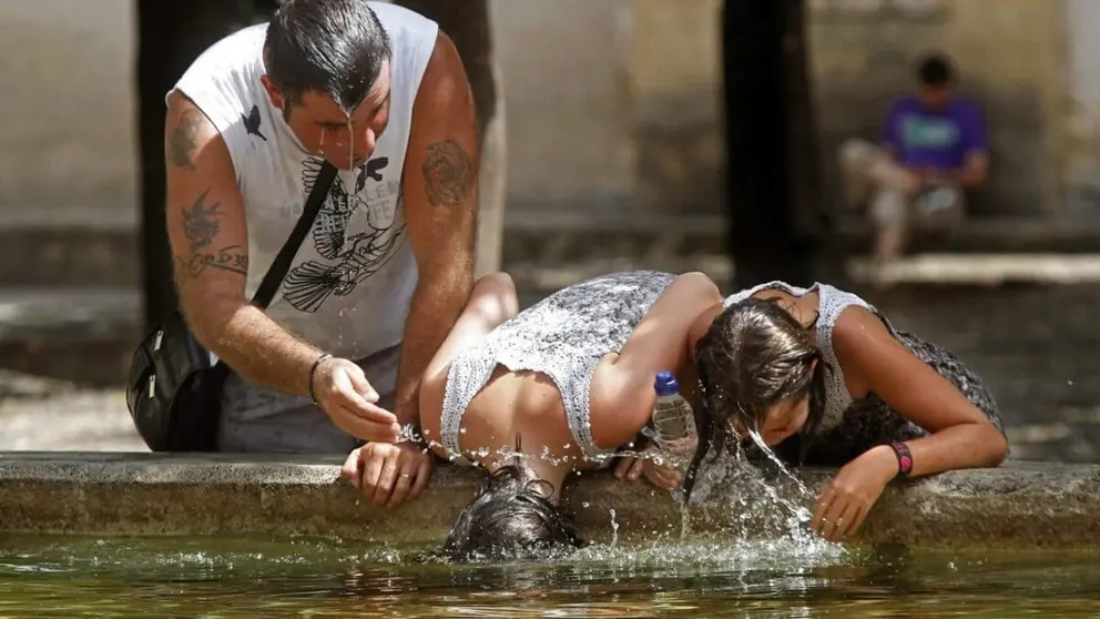Personas se refrescan en una fuente para combatir el calor