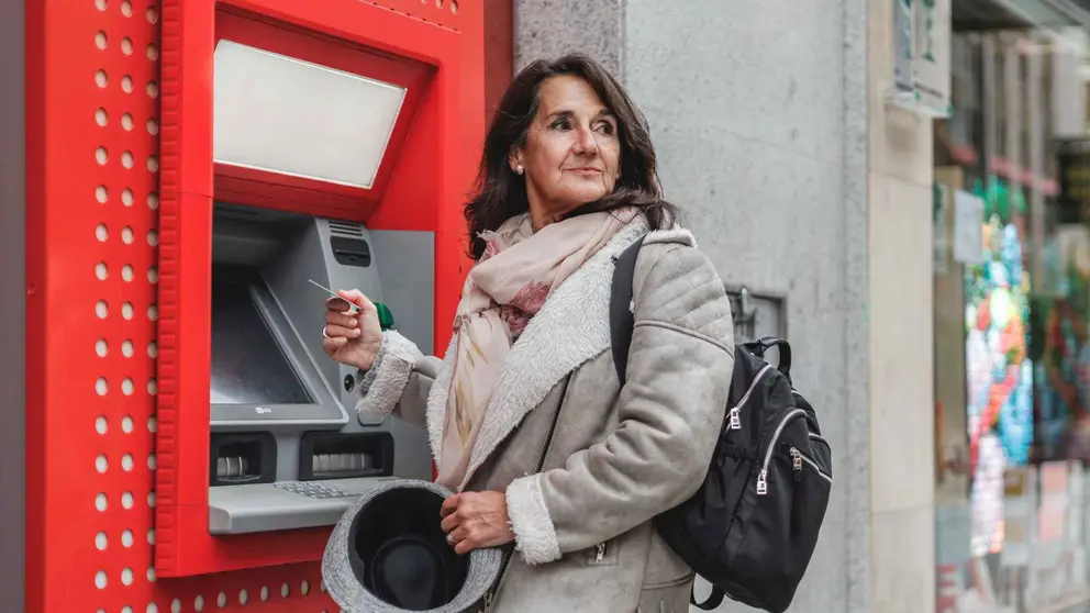 Una pensionista de la Seguridad Social sacando dinero del banco