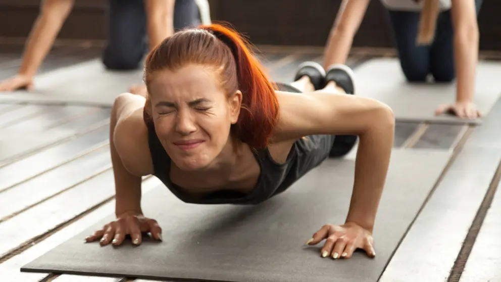 Mujer se esfuerza durante una clase fitness en el gimnasio