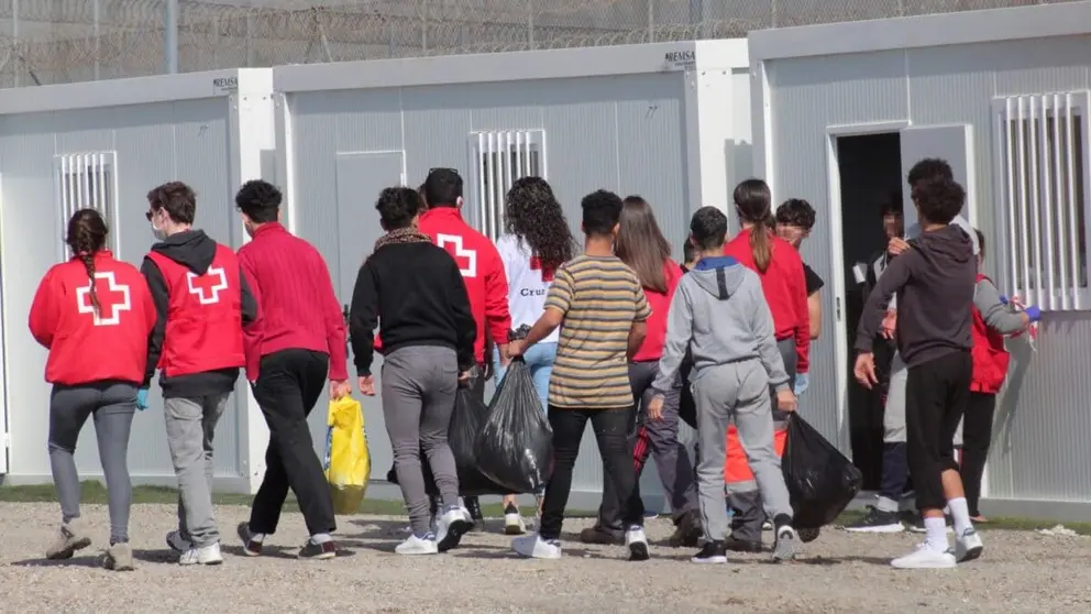 Un grupo de menores extranjeros, acompa&ntilde;ados por voluntarios de la Cruz Roja, llegan a un albergue