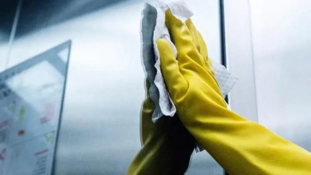 Una persona desinfectando un ascensor