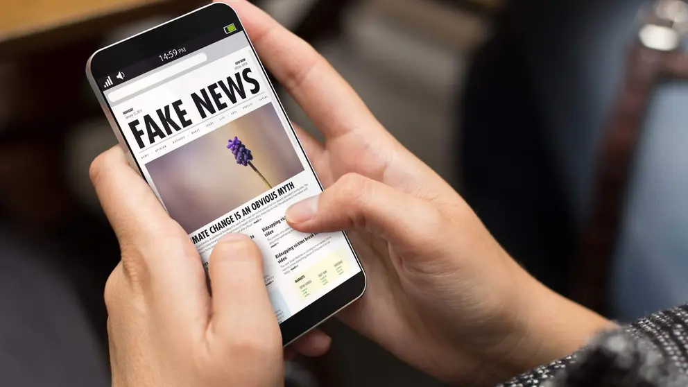 M&oacute;vil con web de titular Fake News