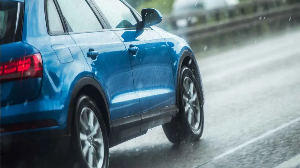 Un coche circulando bajo la lluvia