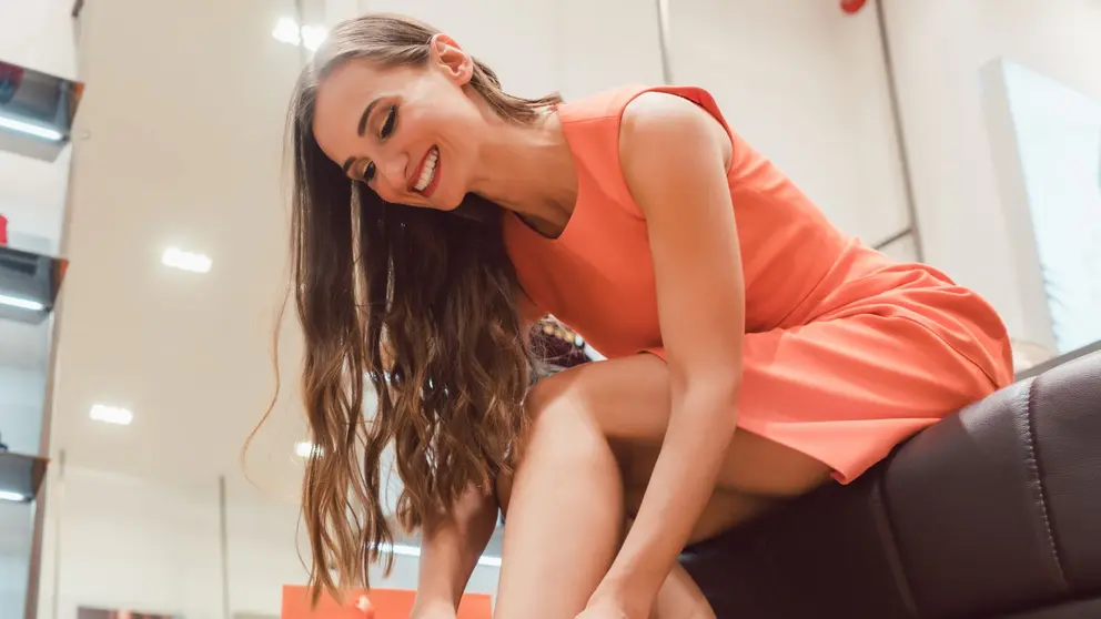 Mujer se coloca una botas en la secci&oacute;n de calzado