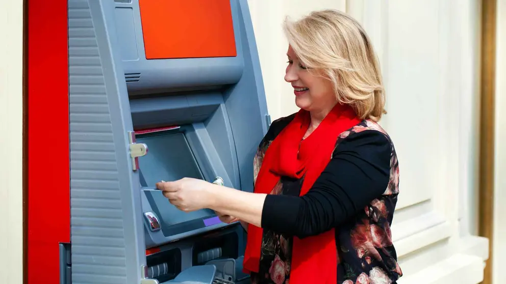 Una pensionista retira dinero del cajero