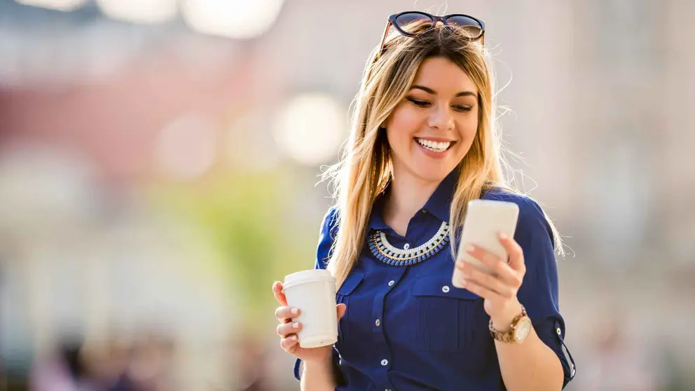 Una joven viendo el m&oacute;vil