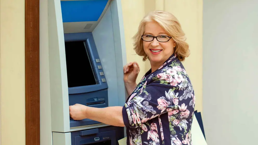 Una pensionista de la Seguridad Social retira dinero del banco