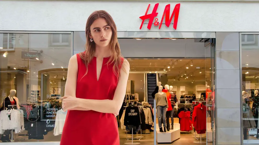 Una mujer a la moda frente a una tienda de H&M