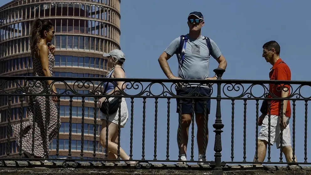 Varias personas pasean por el puente de Triana en Sevilla