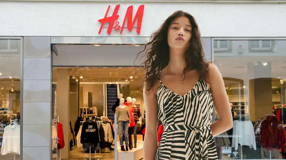 Una mujer a la moda frente a una tienda de H&M