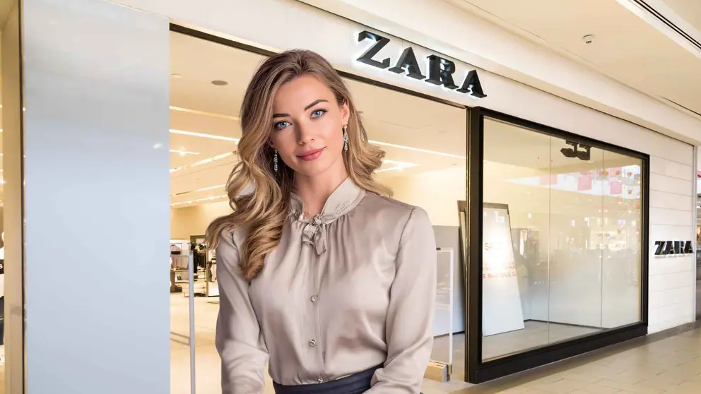Una mujer a la moda frente a una tienda de Zara