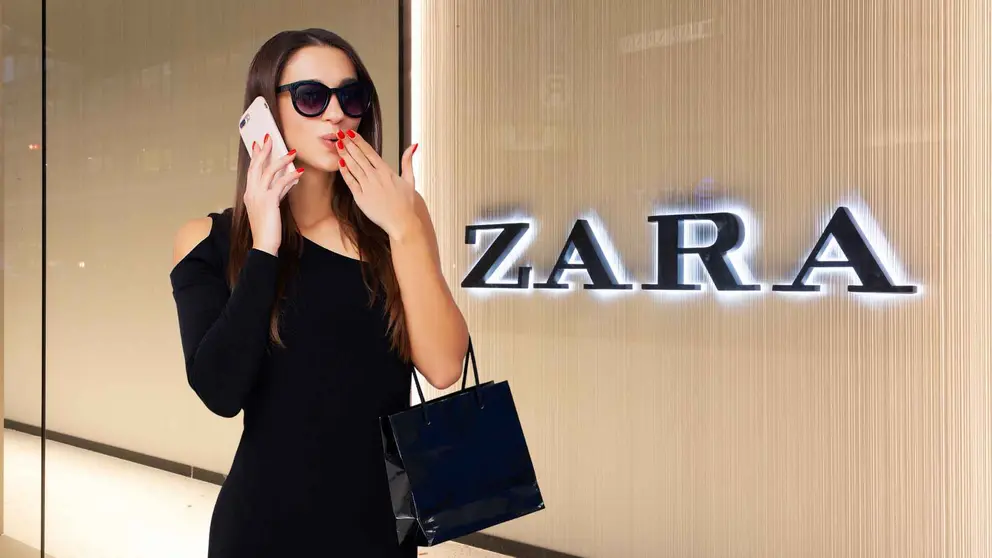 Una mujer a la moda frente a una tienda de Zara