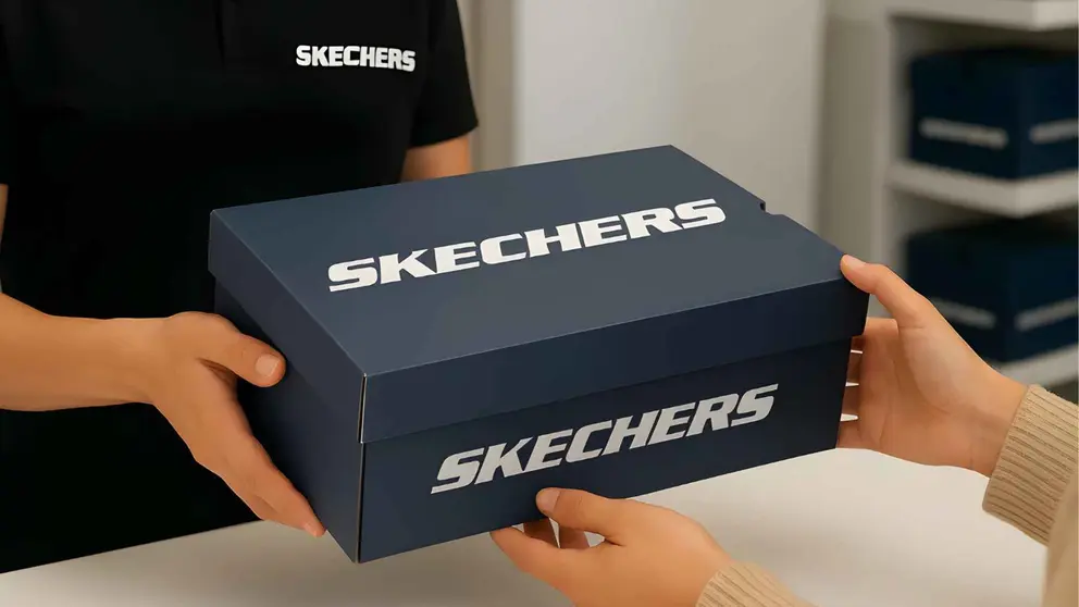 Un vendedor entrega unas cajas de zapatillas Skechers